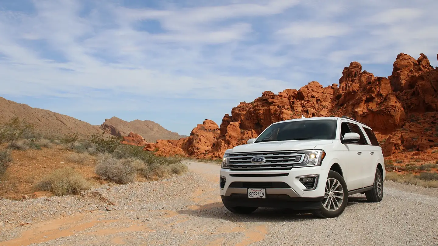 75 Luxuriöser SUV fährt durch die Wüstenlandschaft im Oman mit ihren roten Felsenbergen